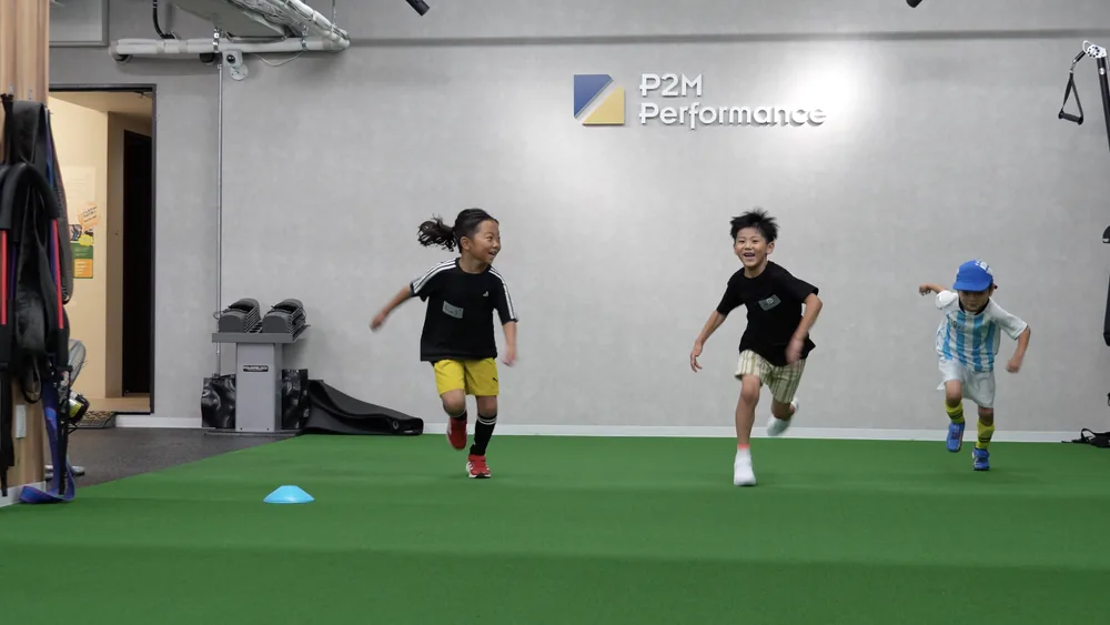 笑顔で全力疾走する小学生たち