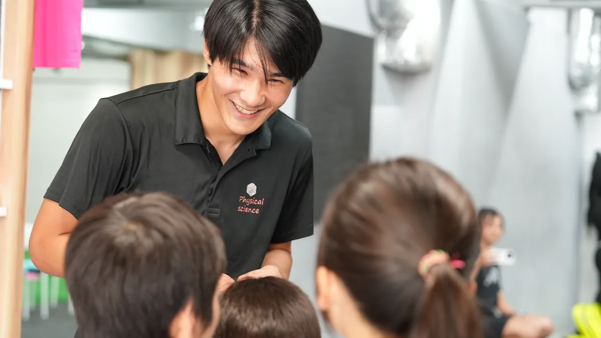 子どもたちに笑顔で話しかけるコーチ