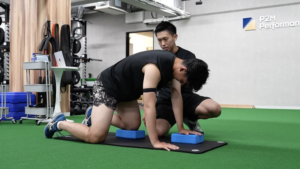 選手の動きに手を添えて可動性を引き出すコレクティブエクササイズ