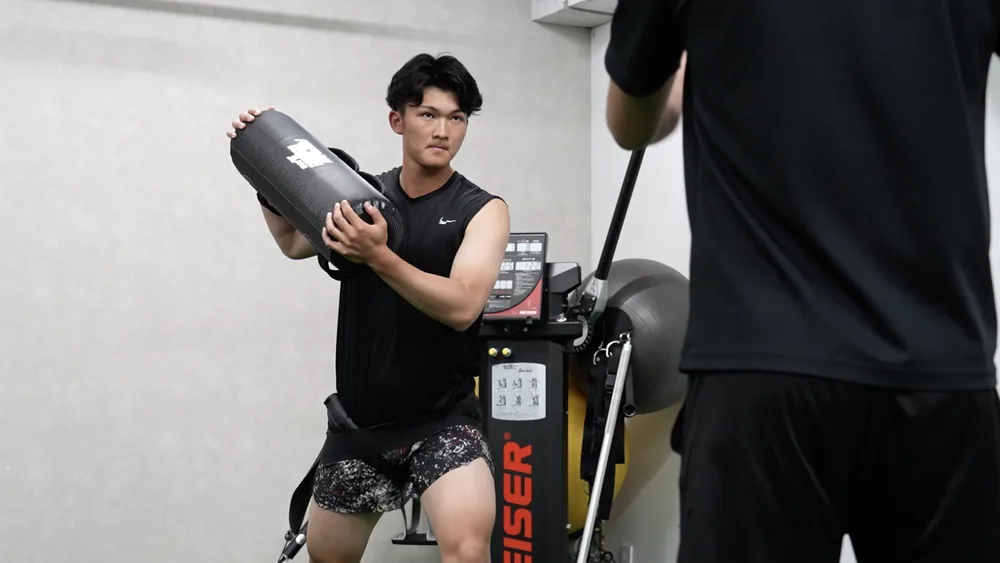 回旋動作のトレーニングに個別に取り組む選手とトレーナー